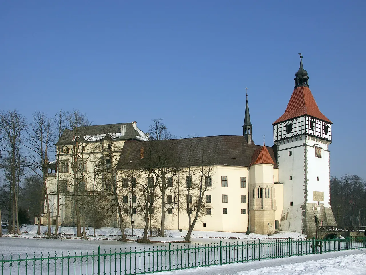 The moated Blatná chateau mirrored in the water.