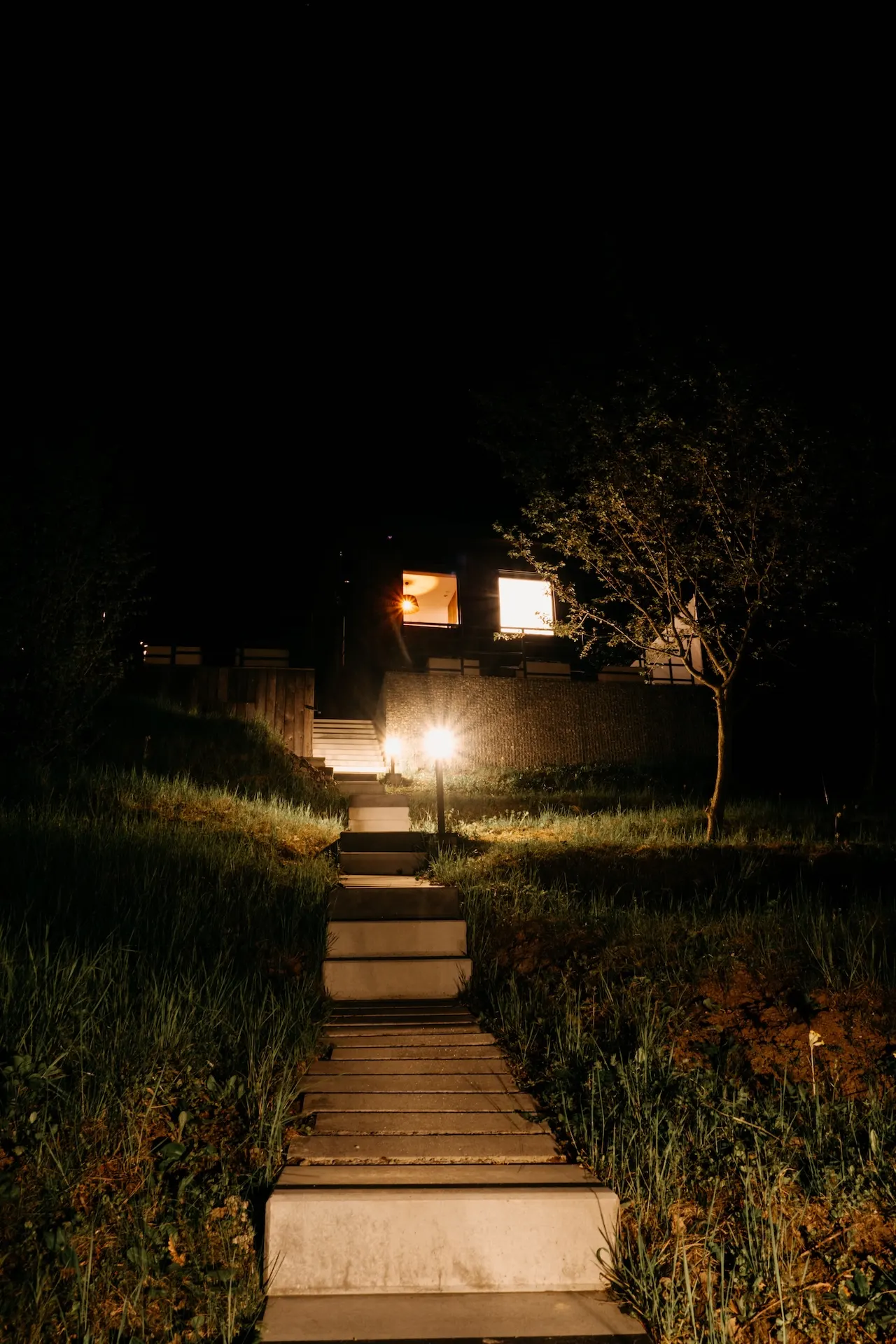 Glamping v noci s osvětlenou cestou.