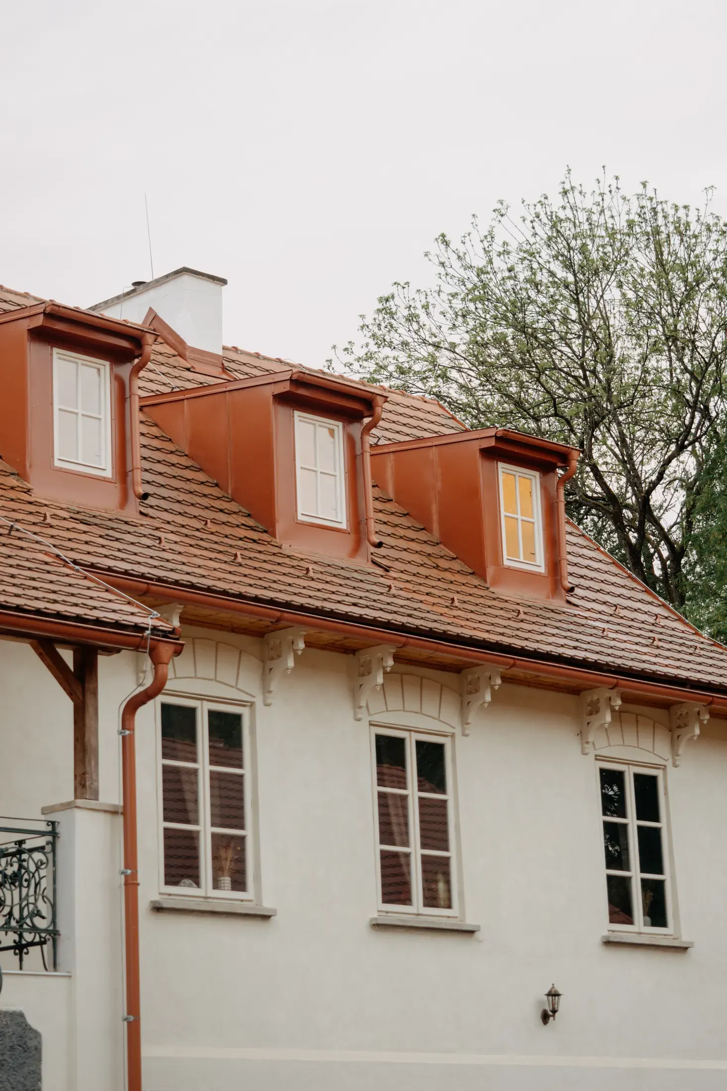 Apartmánové křídlo s mansardovou střechou a vikýři.