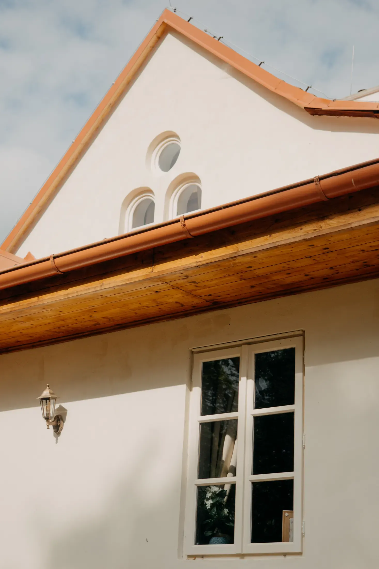 Detail štítu s měděným okapem.