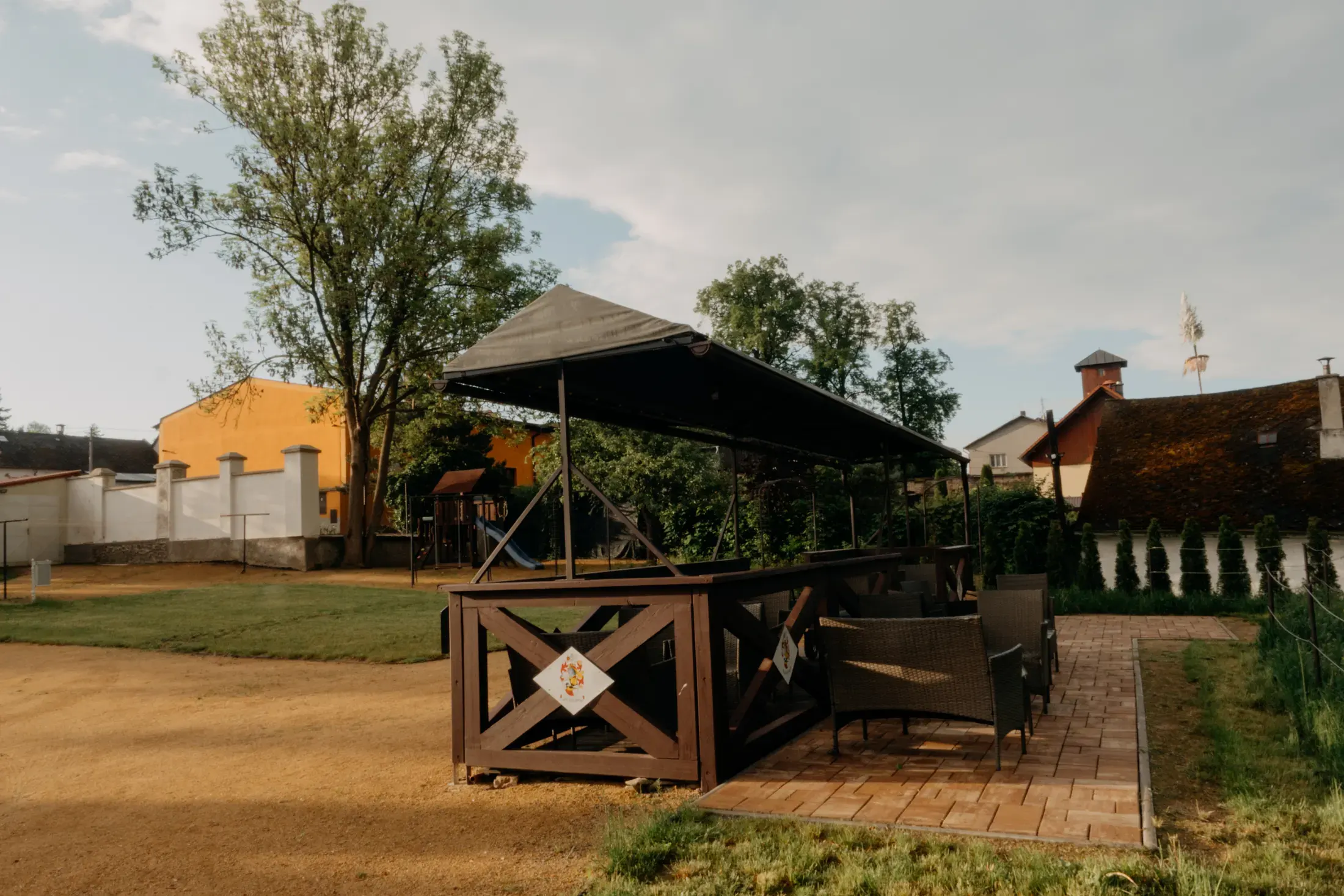 Krytá pergola s posezením v zámeckém areálu.