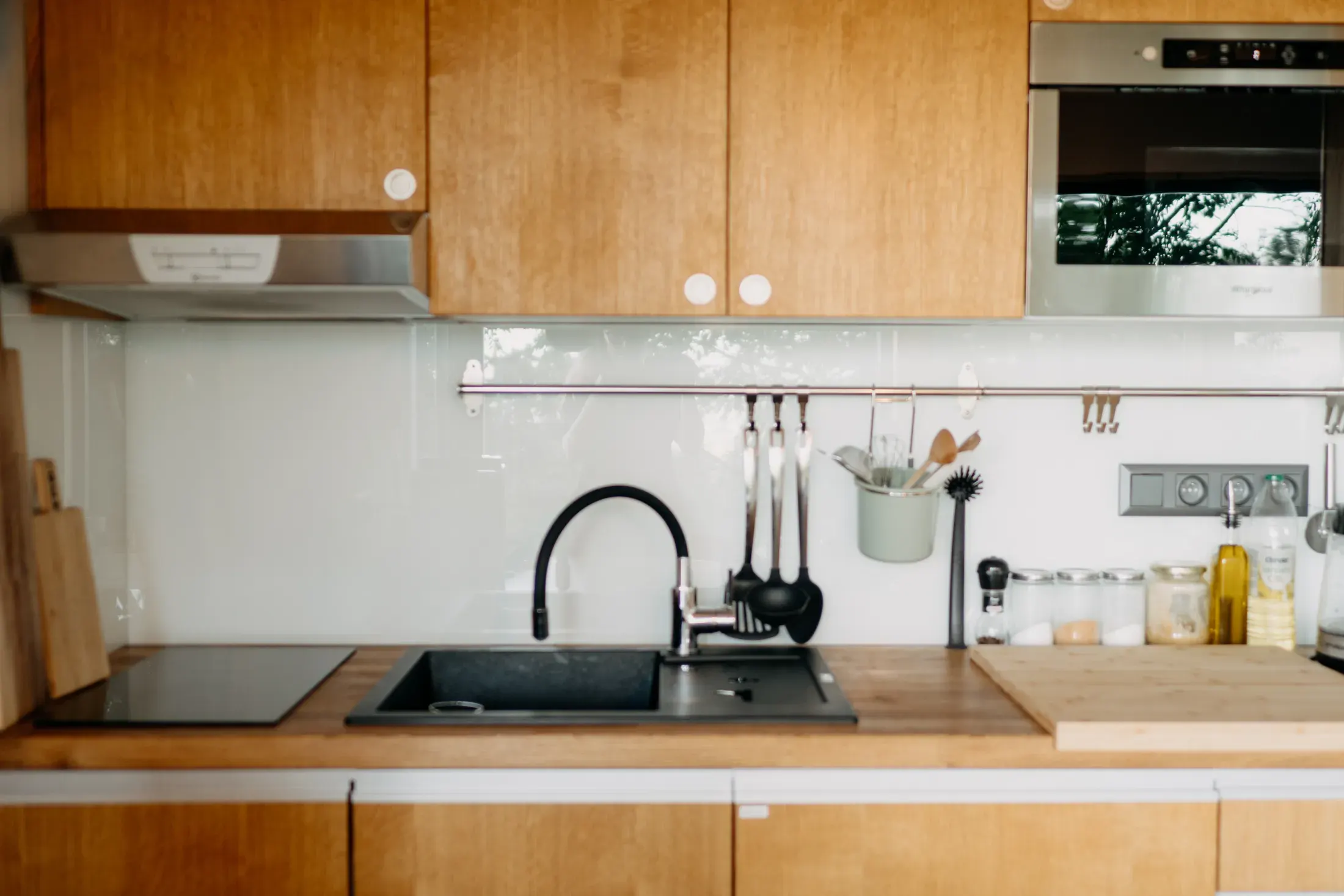 Kitchen detail, a black sink and a wooden worktop.