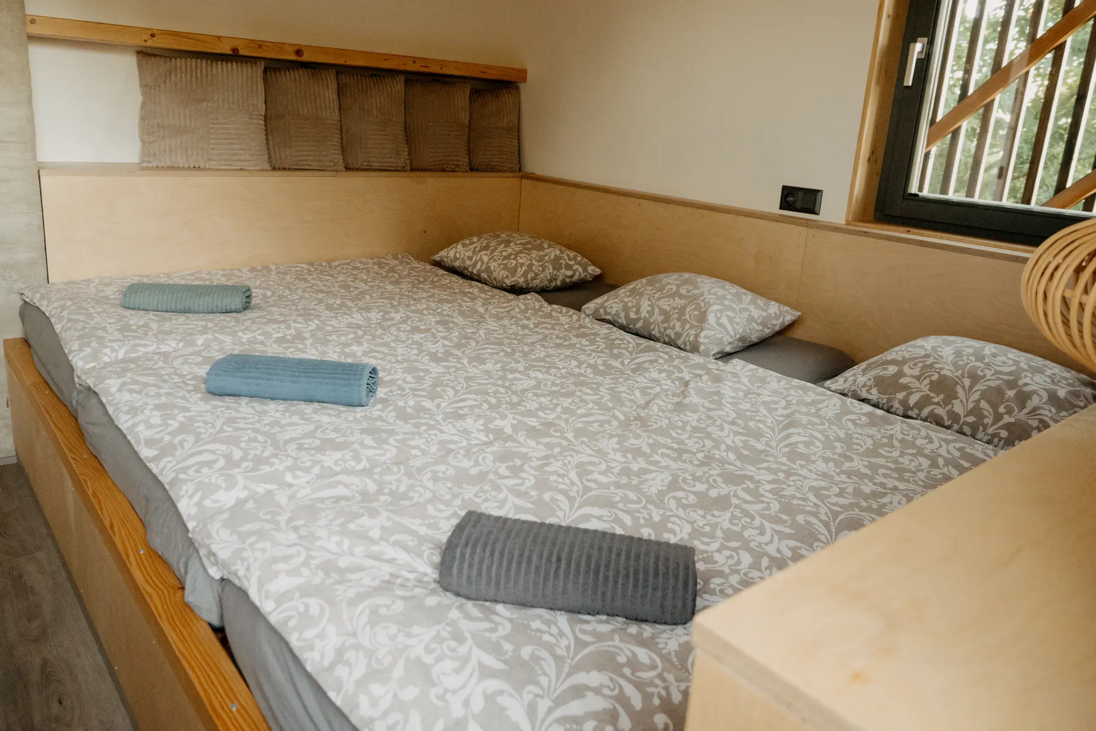 The second room with three beds side by side under the window.