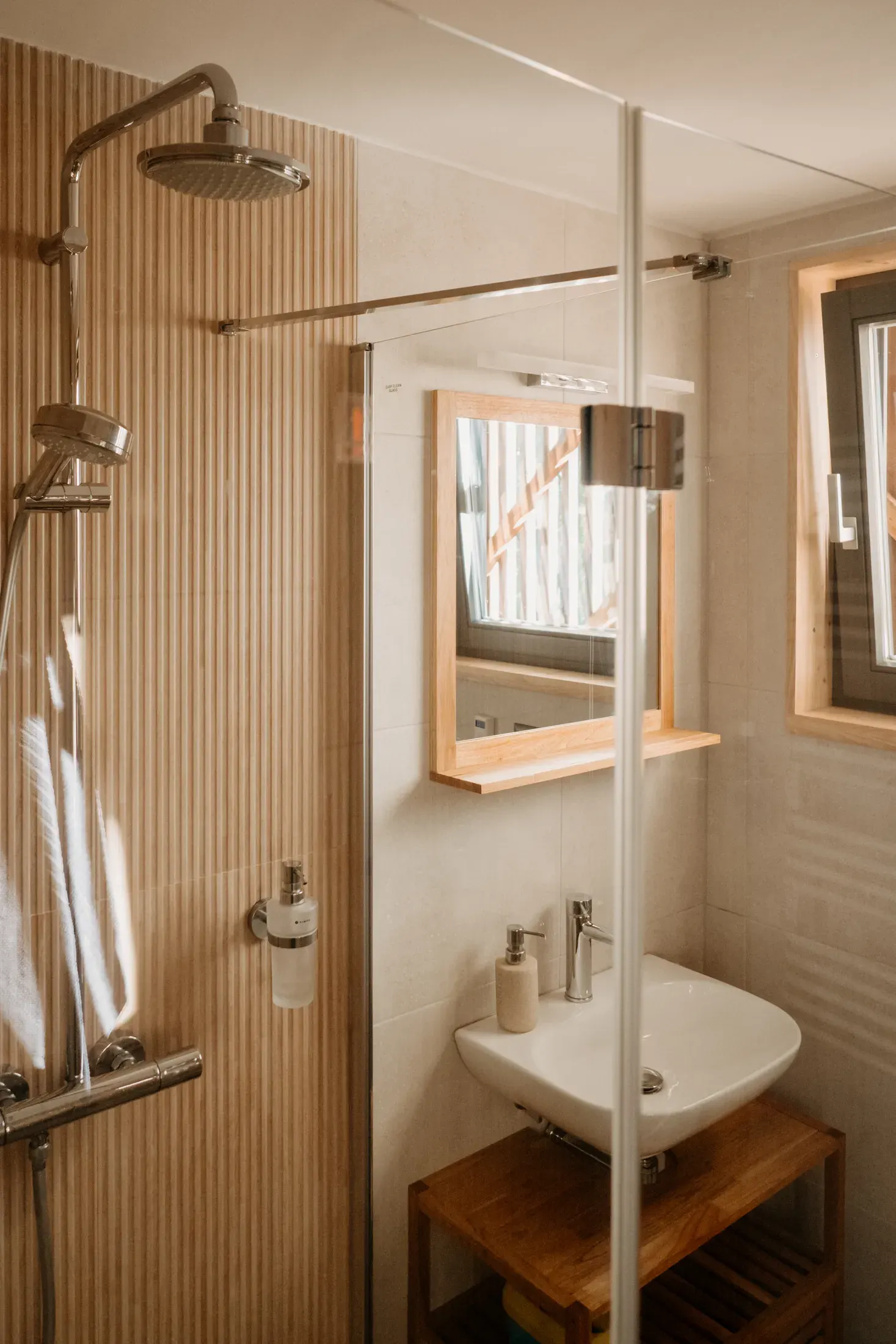The bathroom with a shower enclosure, basin and mirror.