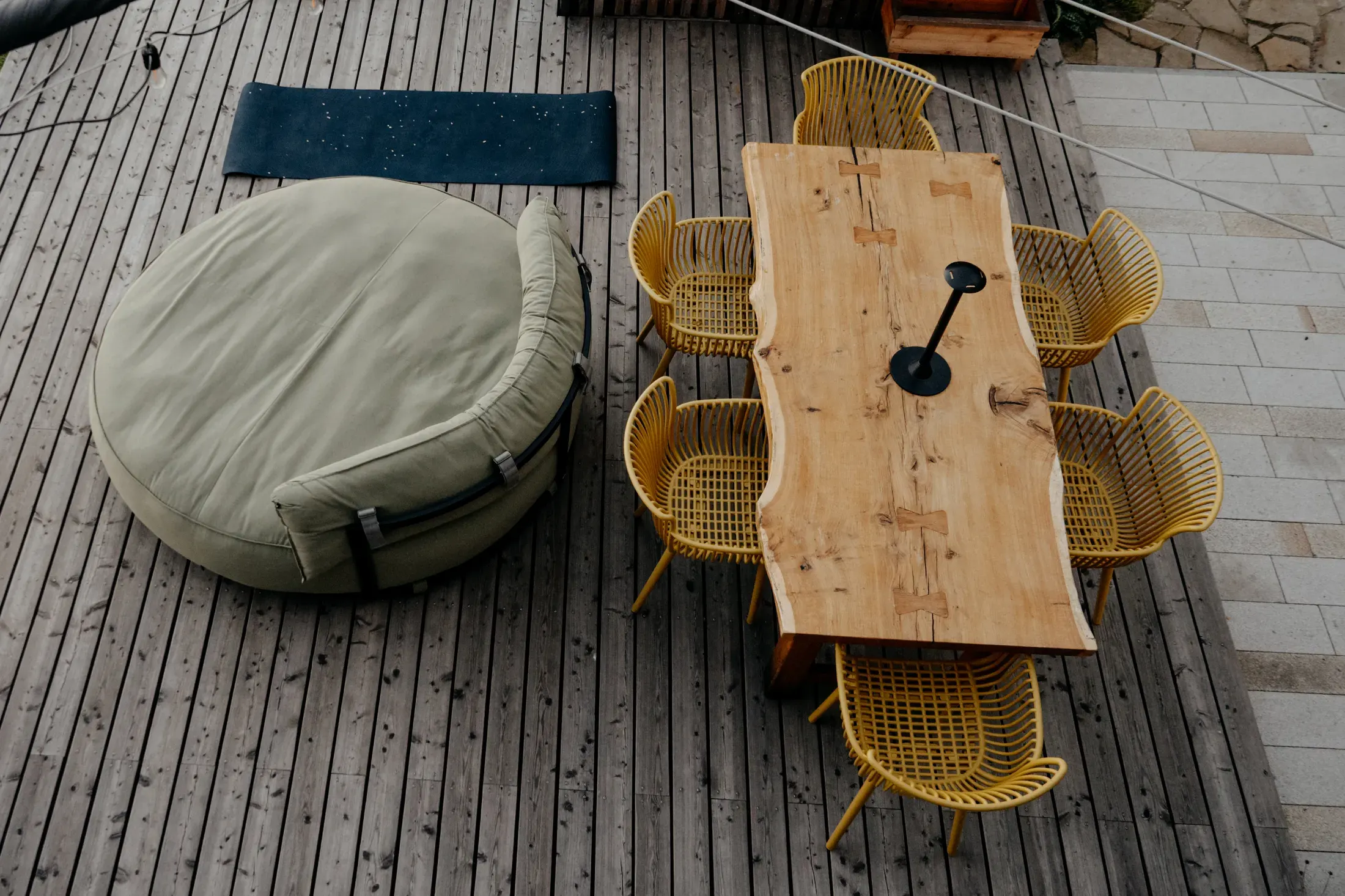 The terrace from above, a solid table with yellow chairs and a round bean bag.