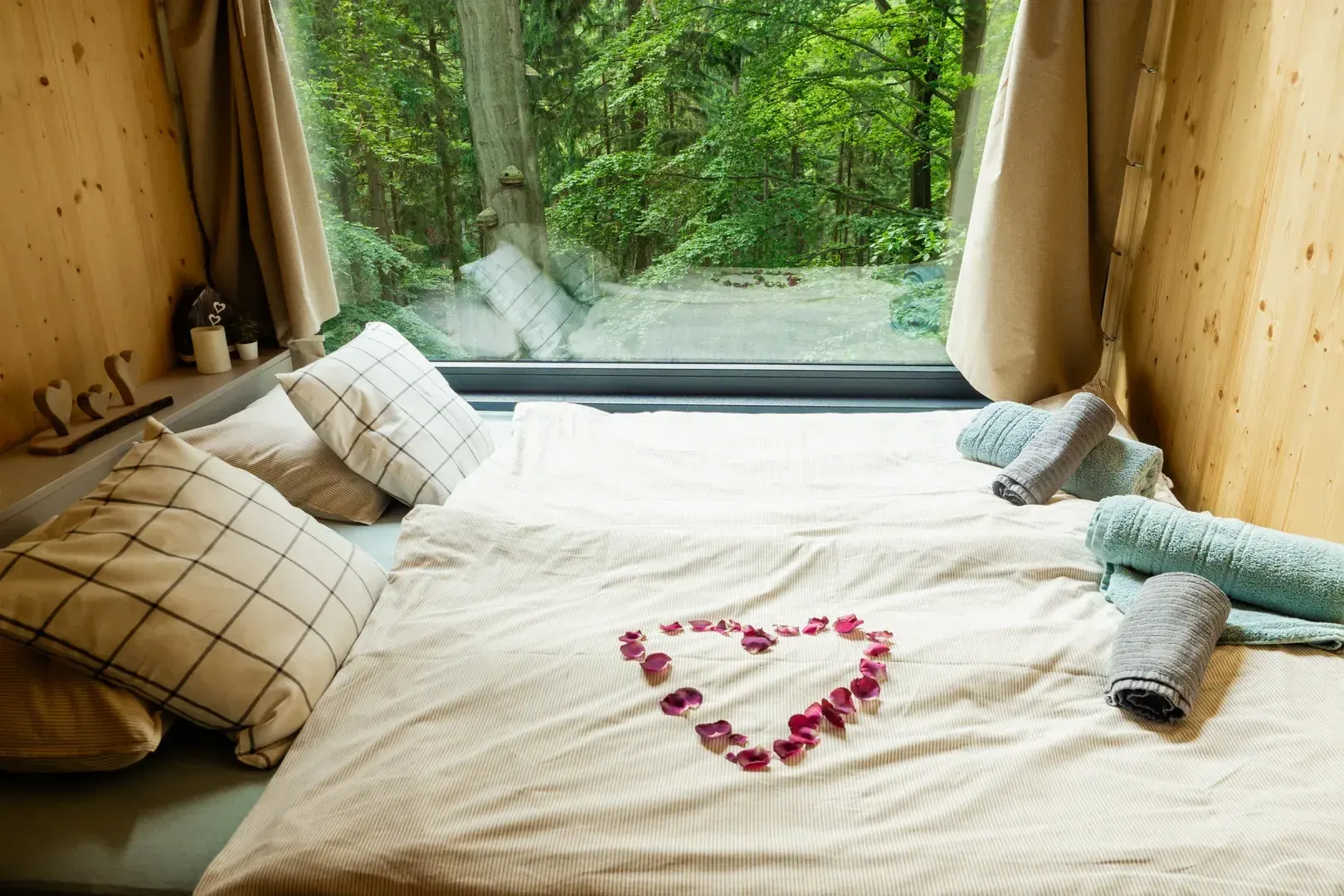 Interiér glampingu s oknem do přírody.