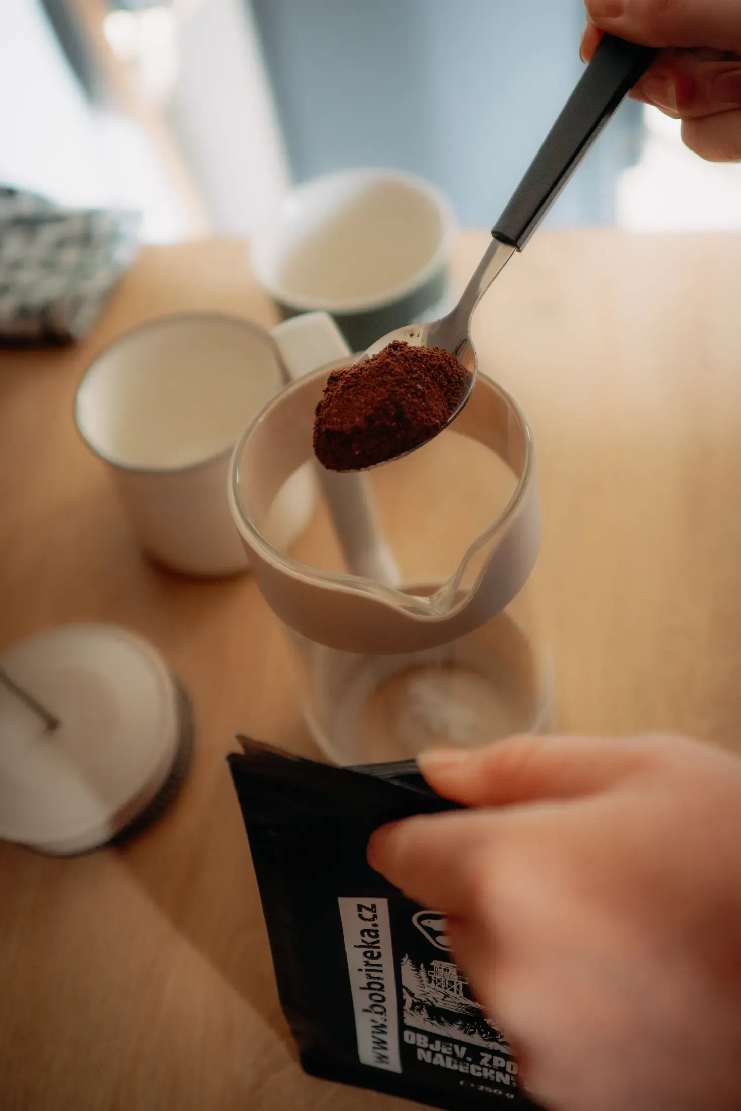 Making coffee, pouring into a mug in the wagon interior.