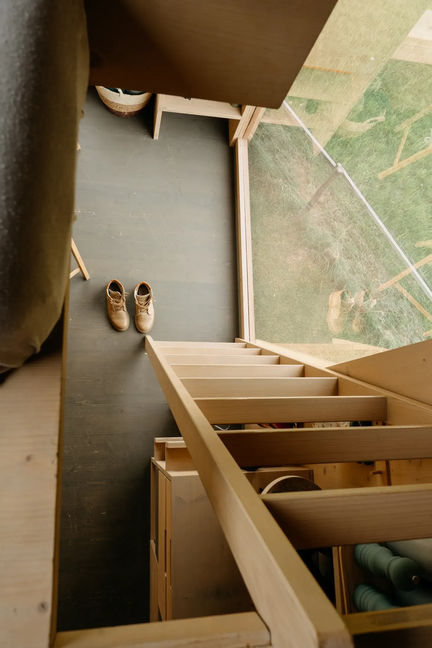 Obytný kout s lapačem snů, lavicí a tkaným kobercem.