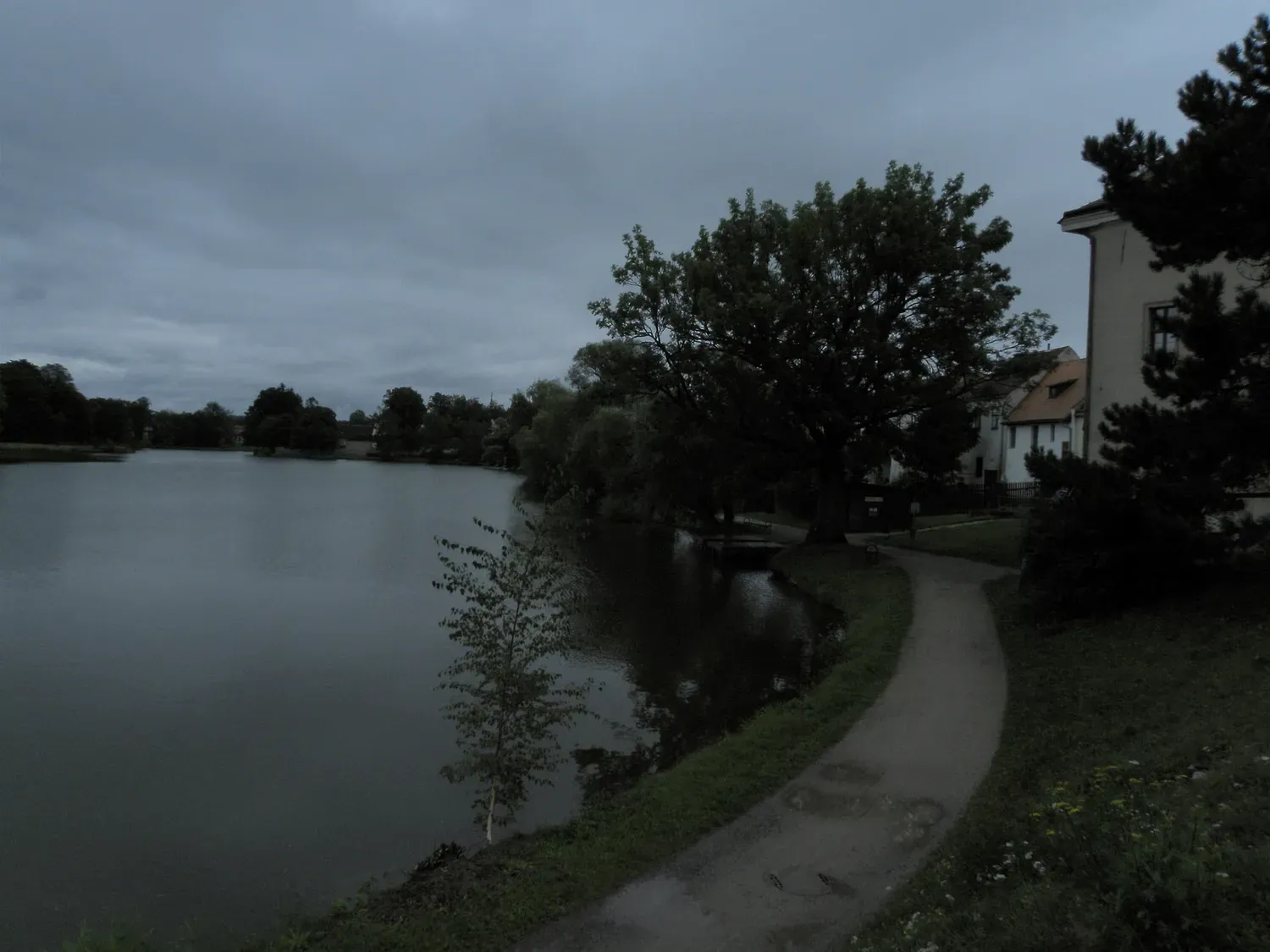 A dam and a path along a South Bohemian pond.