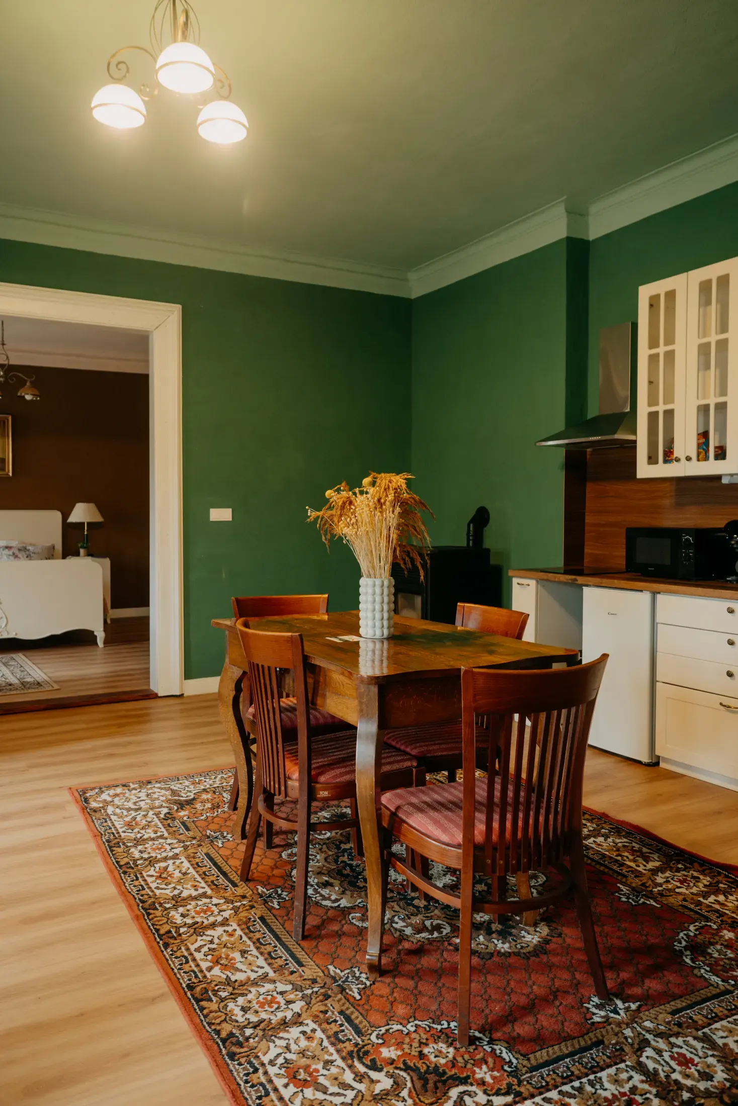 Apartmán Terasa, pokoj se zelenými stěnami a dobovým posezením.
